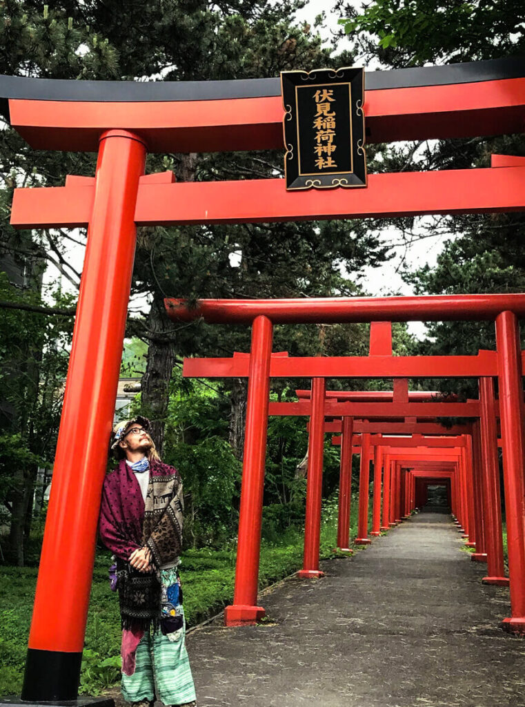 Ziggy standing beneath a Japanese shrine gate in Sapporo, Hokkaido